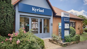 Un edificio con un letrero que dice "Kyriad" y una zona de recepción.