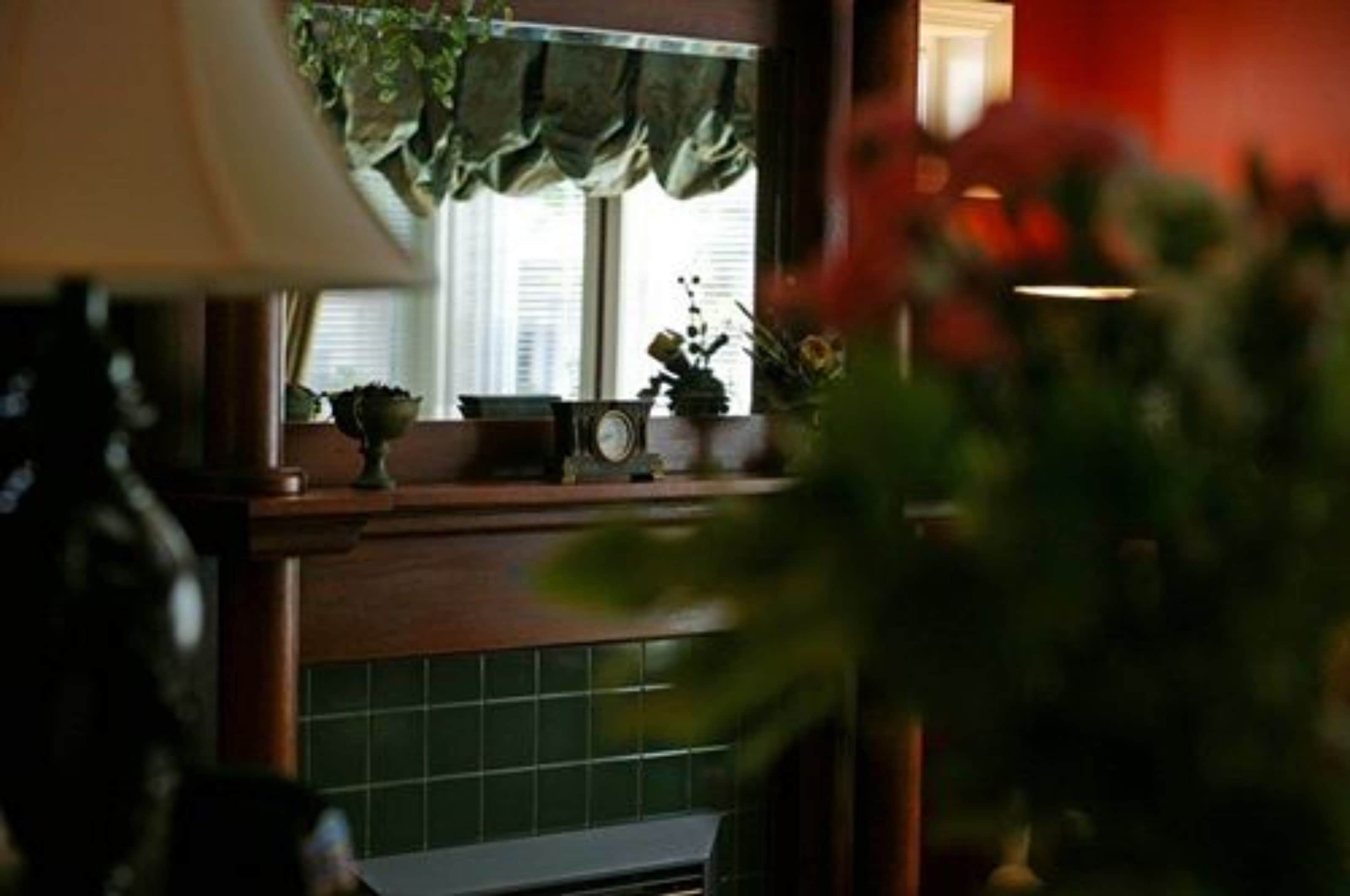 Una cocina con ventana, un reloj y una planta en el alféizar.