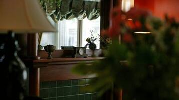 Una cocina con ventana, un reloj y una planta en el alféizar.