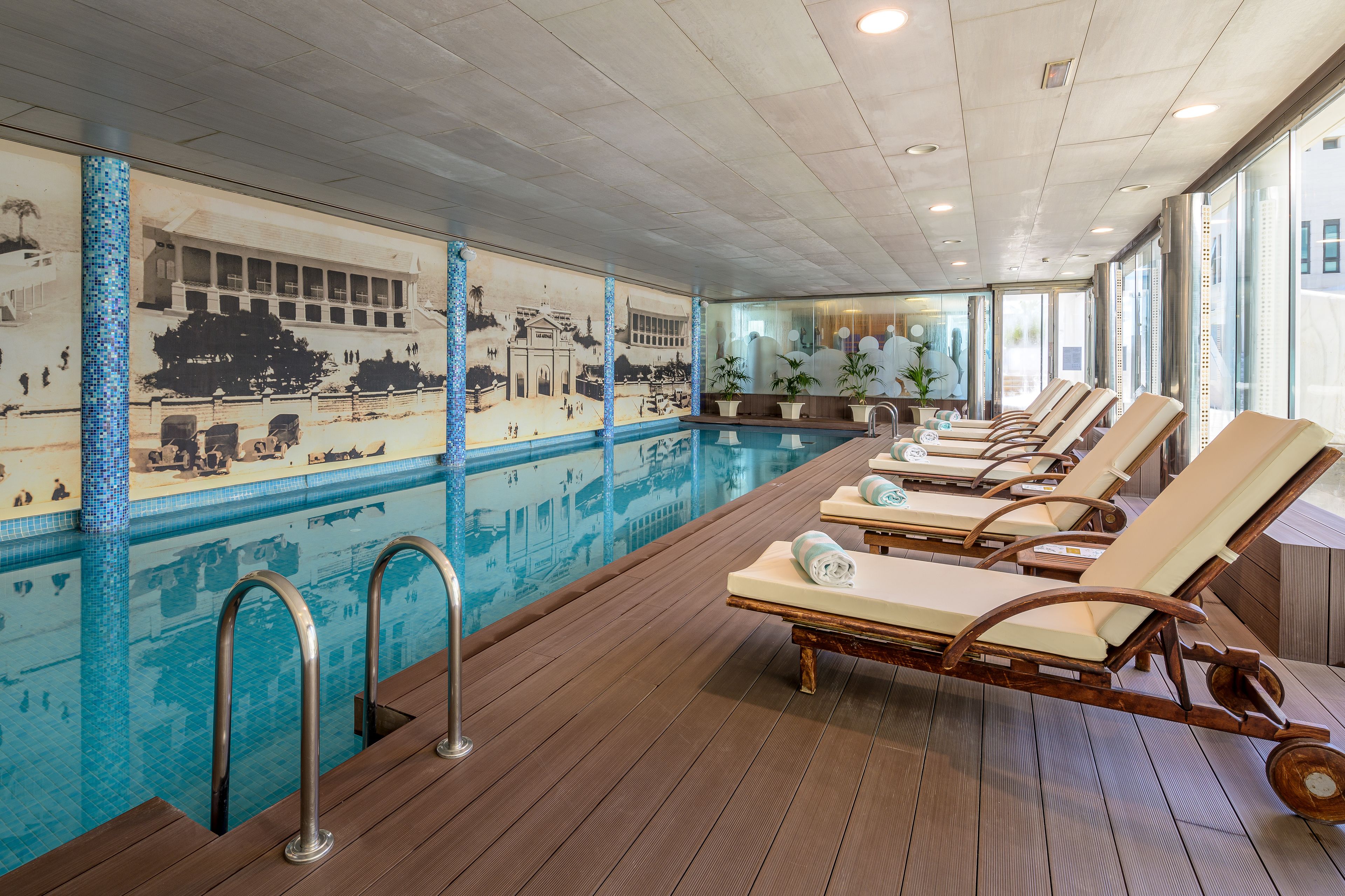 A poolside area with lounge chairs and a tiled mural.
