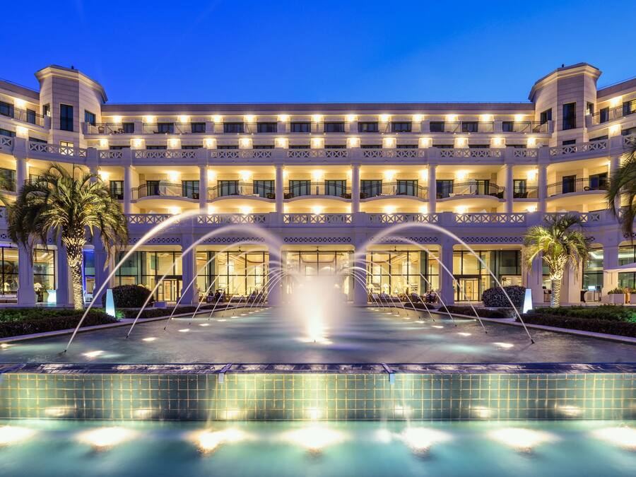 A hotel with a central courtyard, multiple balconies, and a fountain.
