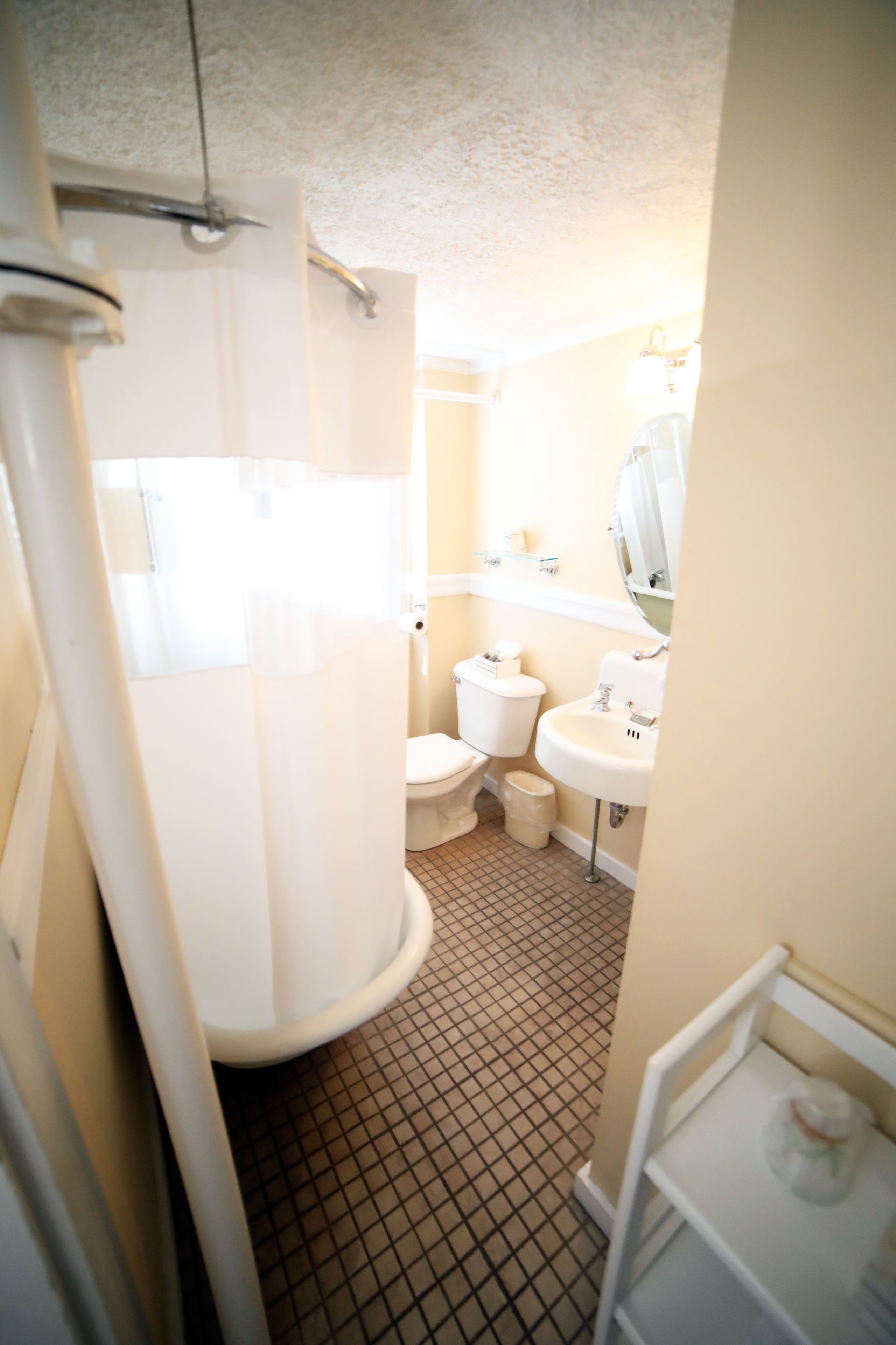 A bathroom with a toilet, sink, and shower area.