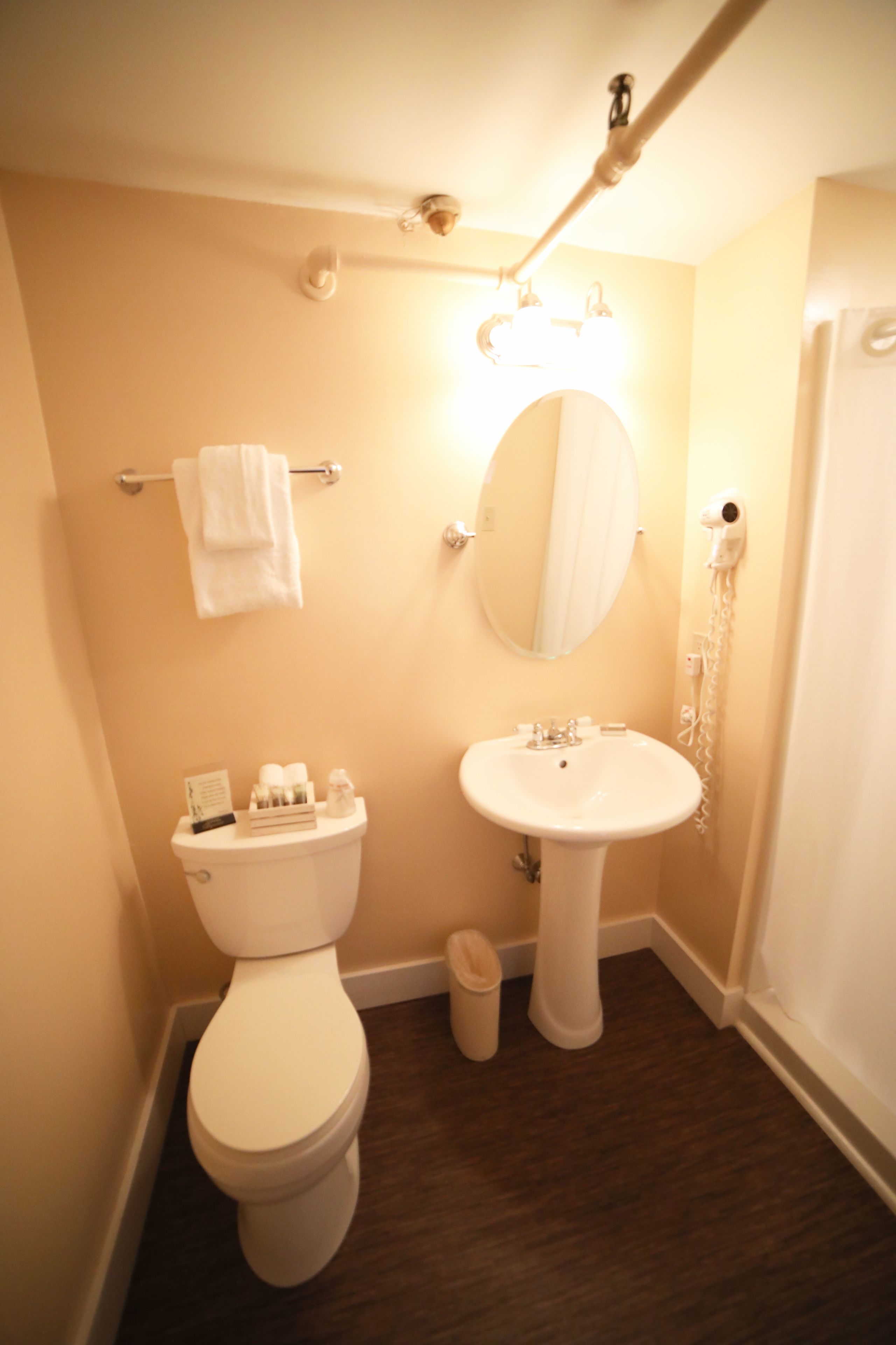 A bathroom with a toilet, sink, and mirror.
