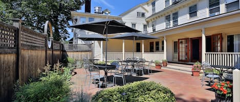 A patio area with outdoor seating, a wooden fence, and a well-maintained garden.