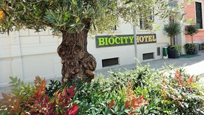 Un arbre se trouve devant l’hôtel Biocity, et une enseigne est fixée au bâtiment.