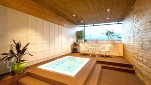 A spa area with a hot tub, wooden flooring, and a view of the outdoors. - Radisson Jaipur City Center (Jaipur)
