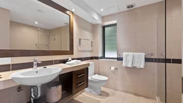 Un baño moderno con un lavamanos grande, inodoro y zona de ducha.