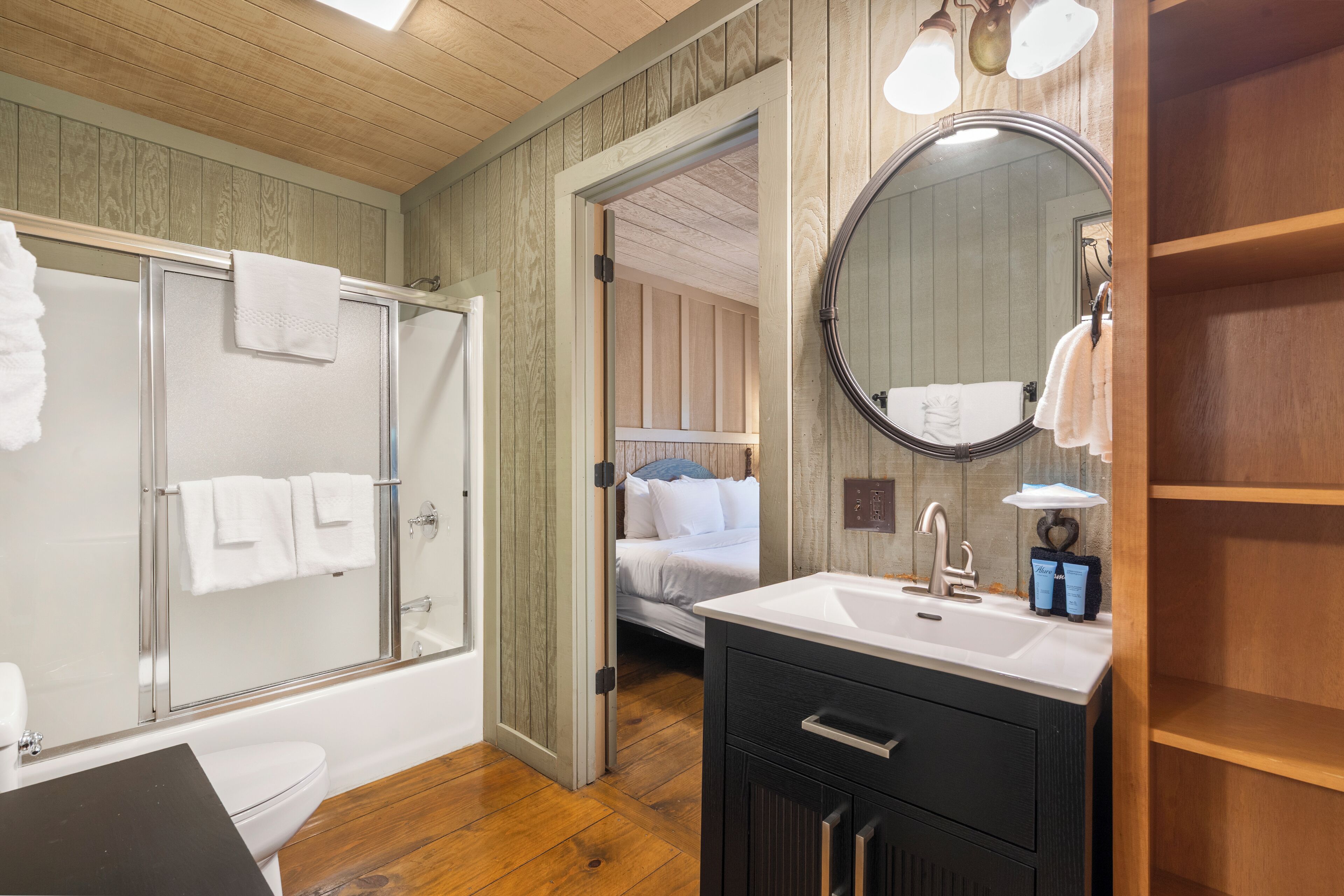 A bathroom with a shower, toilet, sink, and vanity.