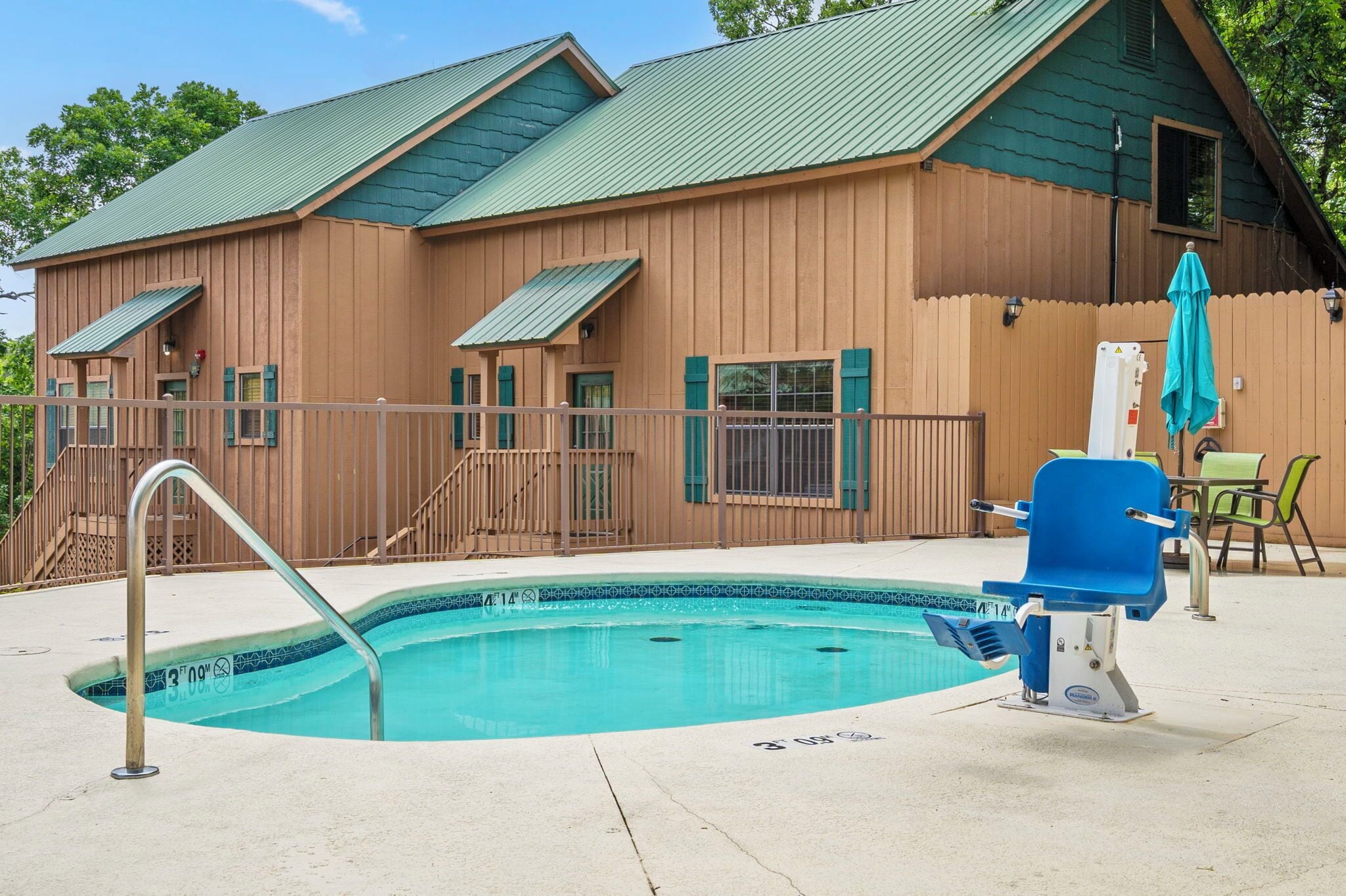 A wooden cabin with a swimming pool, a covered patio, and a chair.