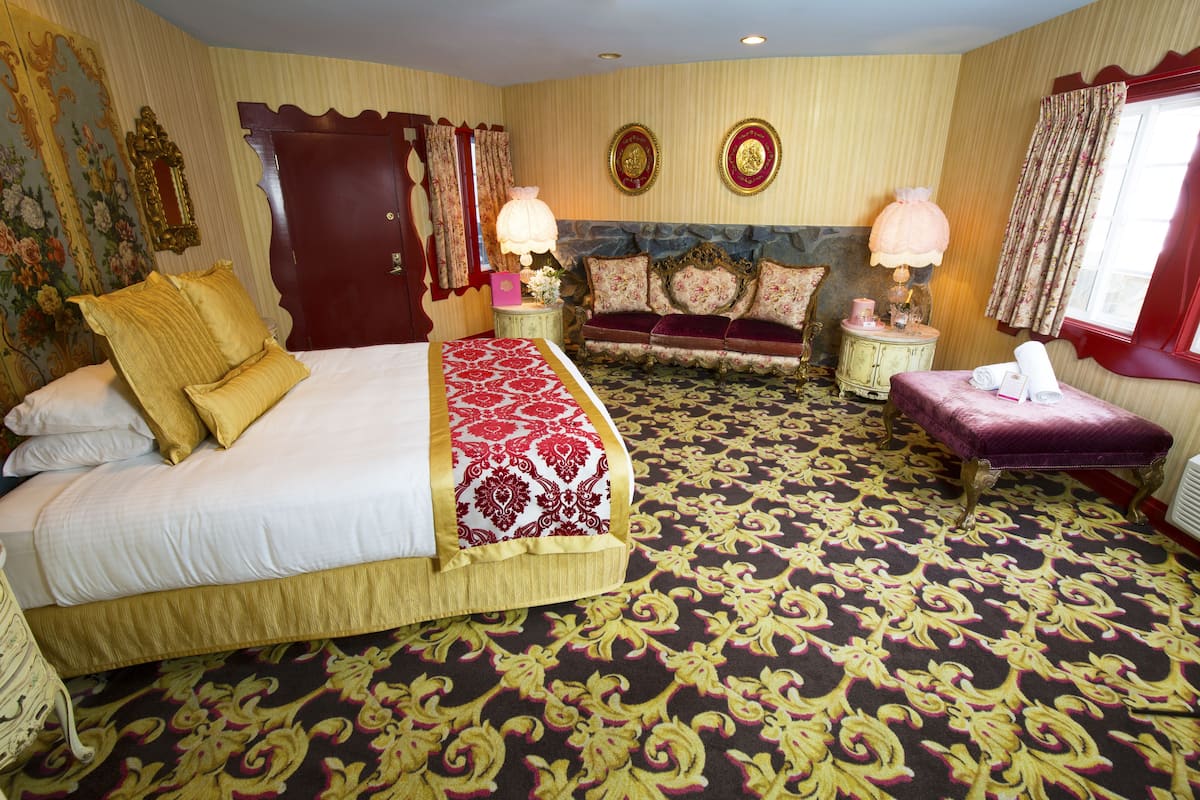 Ein geräumiges Hotelzimmer mit einem großen Bett, einer Couch und einer Bank.