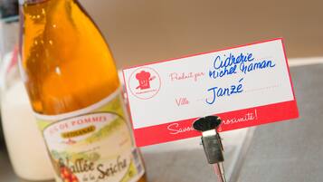 Una botella de sidra de manzana y una tarjeta con texto en francés.