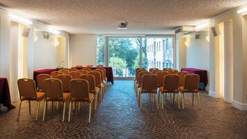 A conference room with a long table and chairs facing a large window.