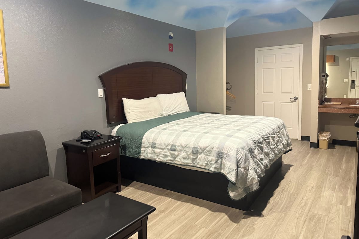 A bedroom with a bed, bedside table, and a nightstand.