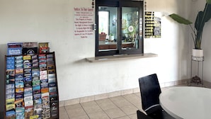 Een receptie met een boekenpresentatie, een prikbord en een grote potplant.