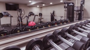 A gym with rows of dumbbells and exercise equipment.