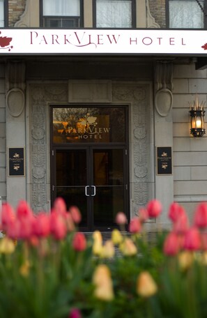 The Parkview Hotel entrance with a prominent sign, decorative stonework, and a flower display in the foreground. - The Parkview Hotel (Syracuse)