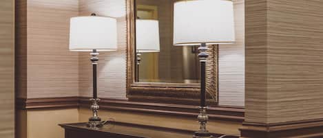Un meuble-lavabo de salle de bain avec deux lampes fixées au mur et un miroir.