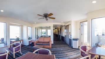 A hotel lobby with a central seating area, a ceiling fan, and a patterned carpet.