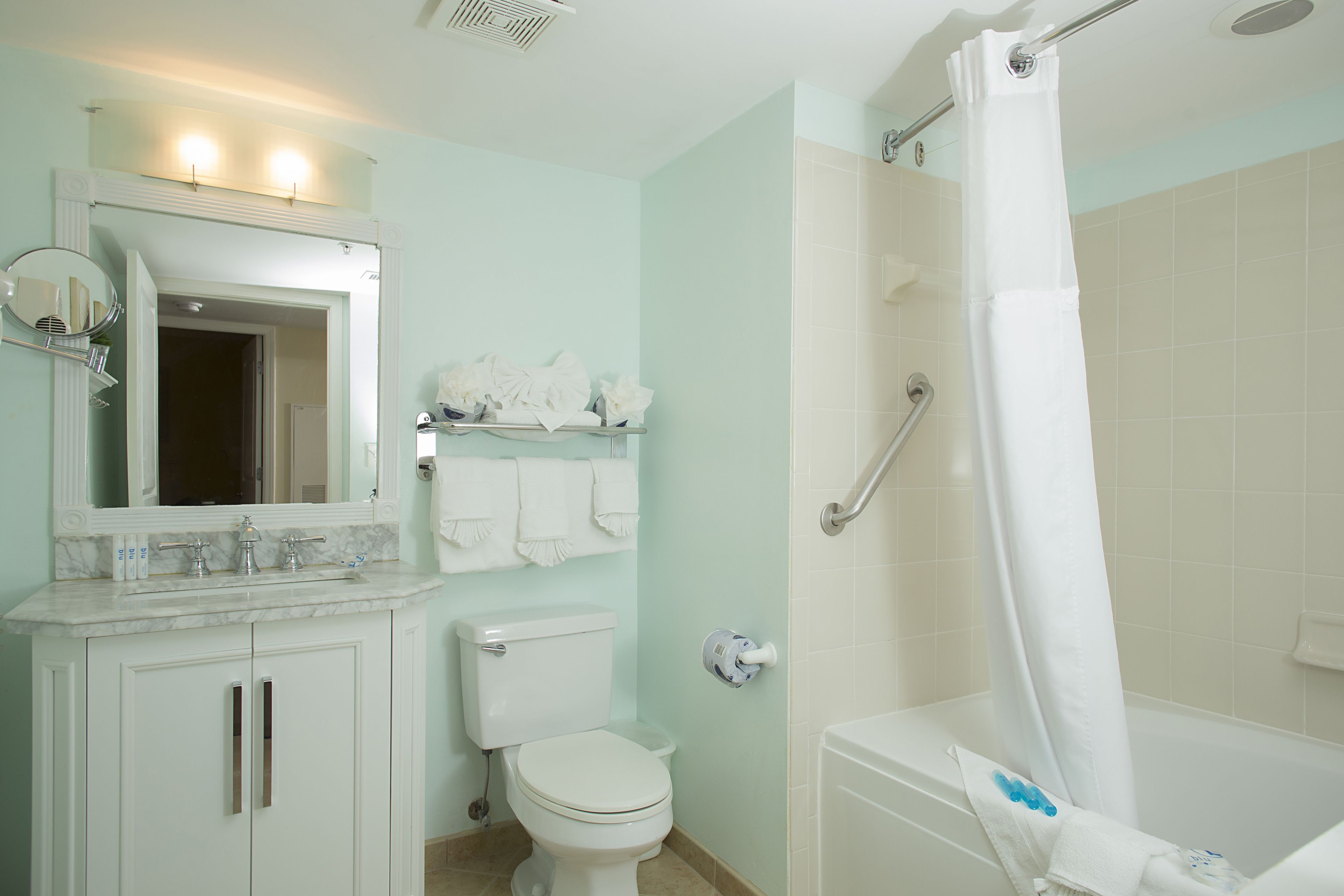 Un baño con inodoro, lavamanos y zona de ducha.