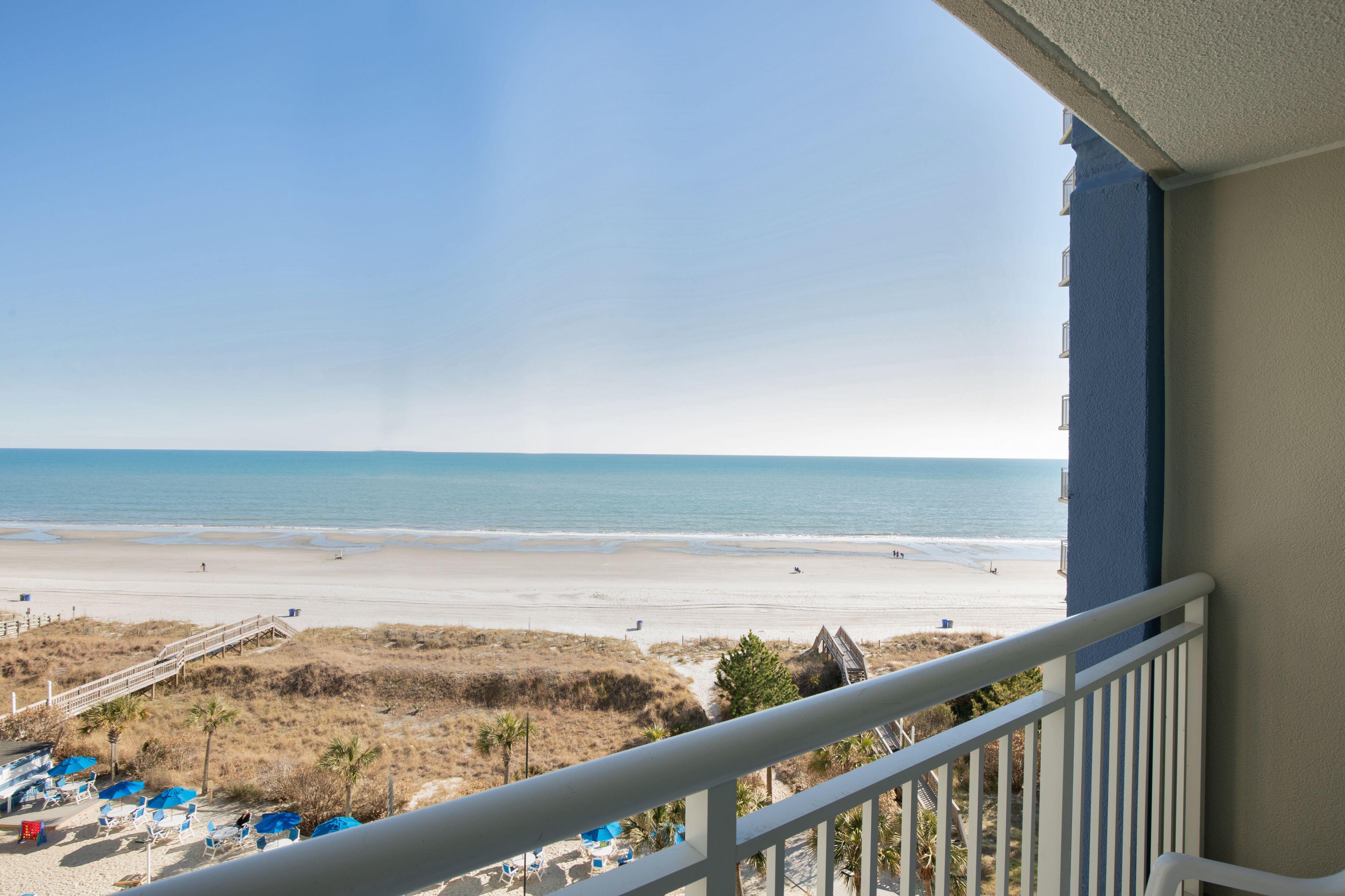 A balcony with a view of a beach and ocean.