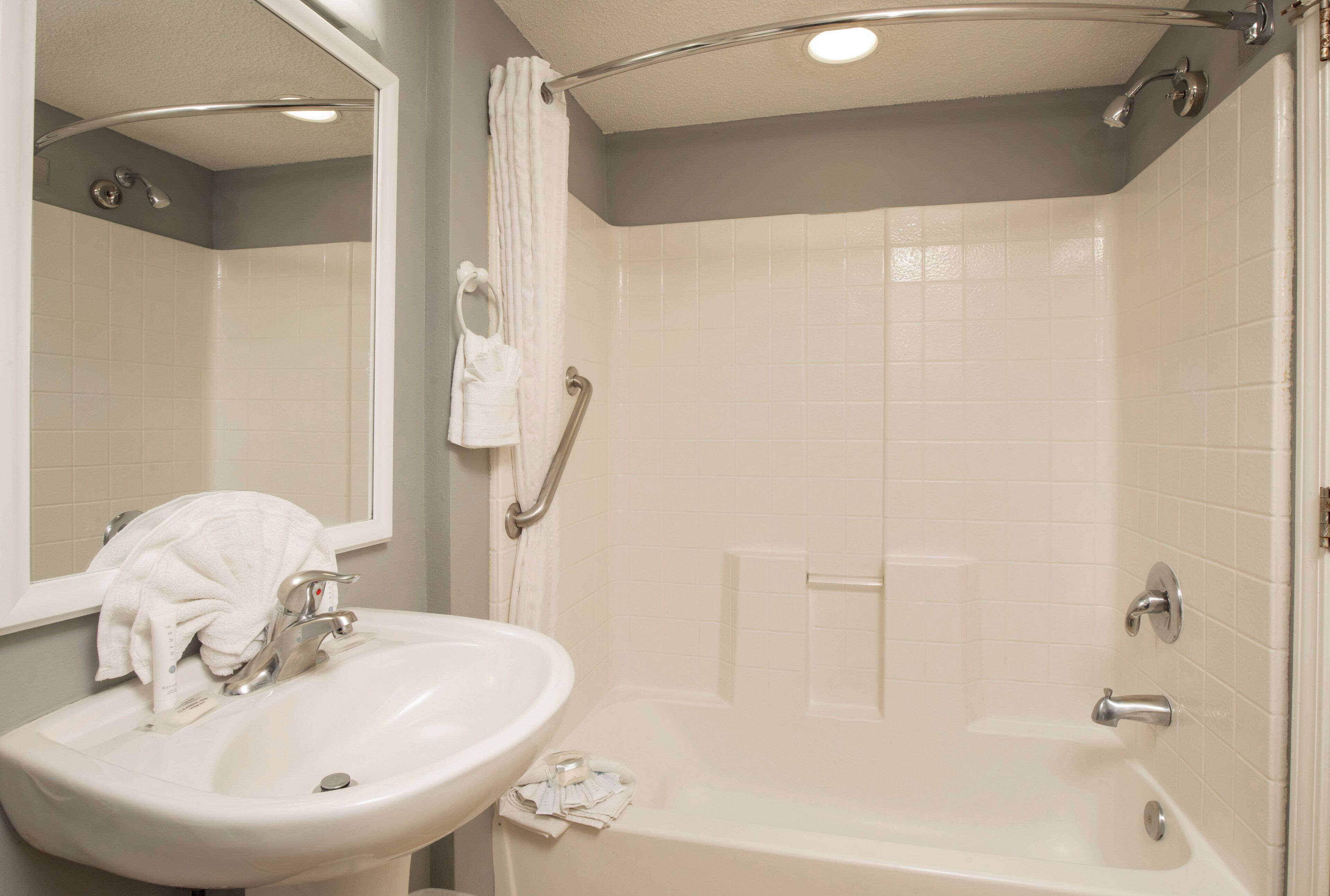 Une salle de bain équipée d’un lavabo, d’un miroir, d’une douche et d’une baignoire.