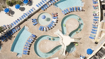 Relax by the pool, surrounded by palm trees and a sandy beach, with lounge chairs and umbrellas for comfort.