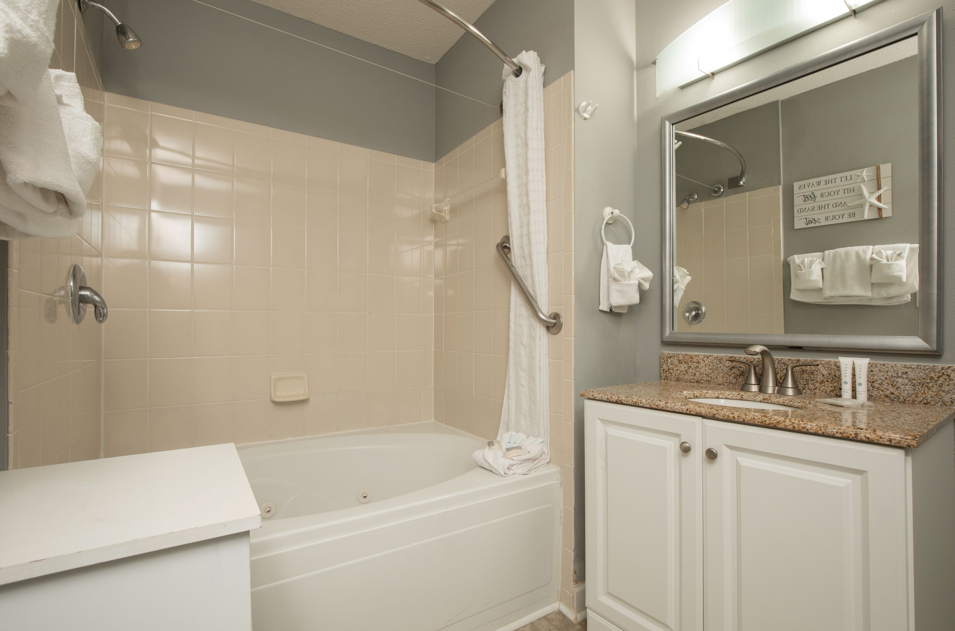 Une salle de bain avec une baignoire, une douche, un lavabo et un miroir.