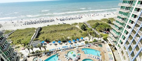 Un resort con varias piscinas, playa y vista al océano.