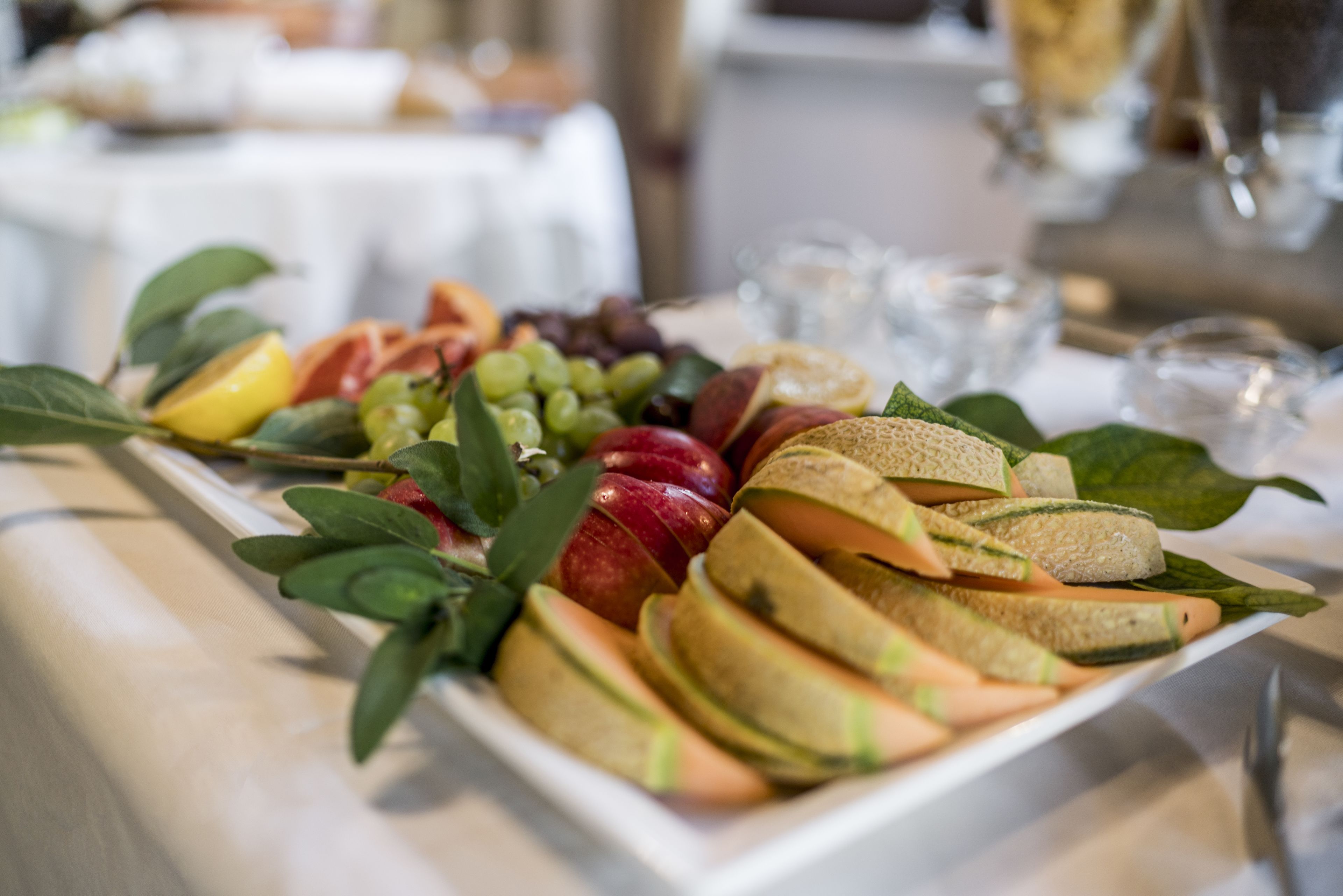 Uma travessa com frutas e legumes variados sobre uma mesa.