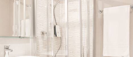 Une salle de bain moderne avec une douche à l’italienne, un lavabo et un bidet.