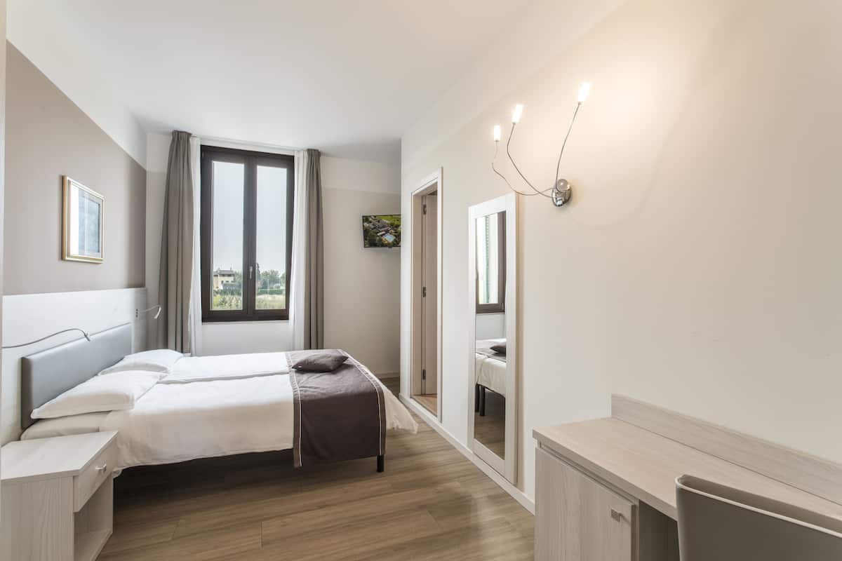 Ein Schlafzimmer mit Bett, Nachttisch und Spiegel.