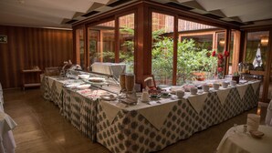 A buffet setup with a variety of food items and a large window offering a view of greenery. - Grand Hotel Terme Tamerici e Principe (Montecatini Terme)