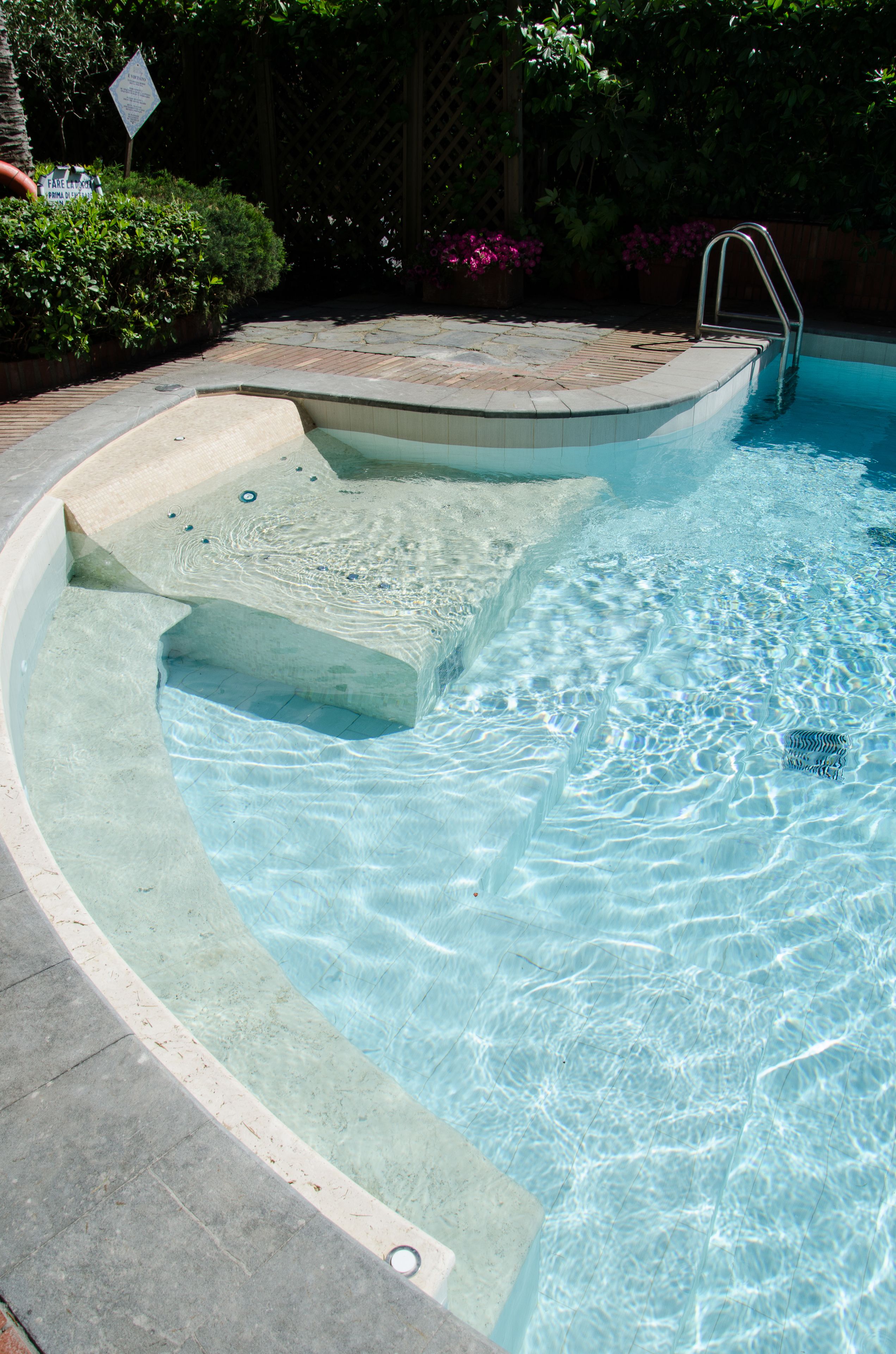 Une piscine dotée d’un jacuzzi intégré et d’une échelle permettant d’y accéder.