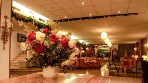 A spacious lobby with a large floral arrangement on a marble table, a grand staircase, and a cozy seating area with multiple chairs and sofas. - Grand Hotel Terme Tamerici e Principe (Montecatini Terme)