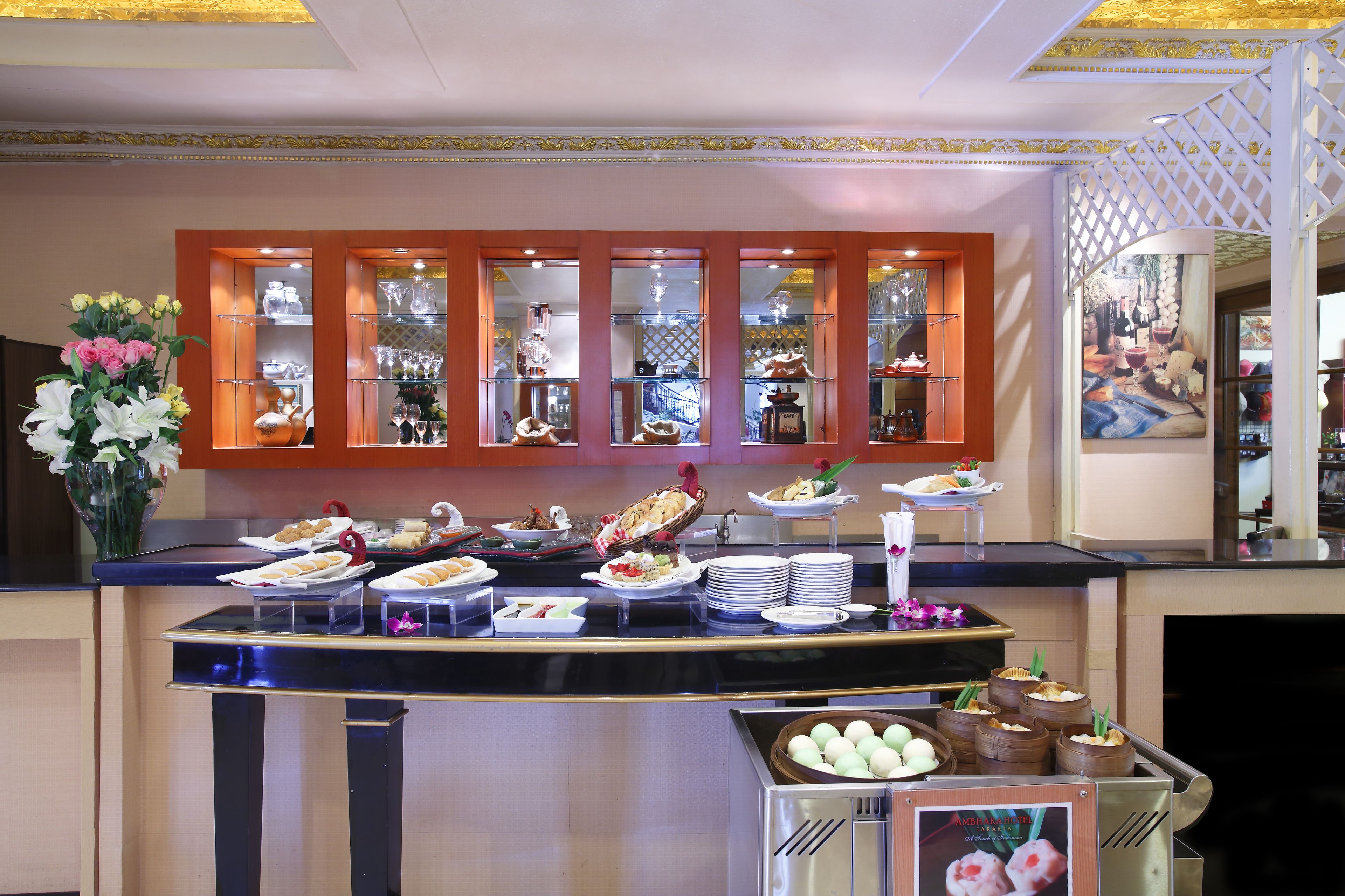 A buffet setup with various food items and a decorative vase of flowers.