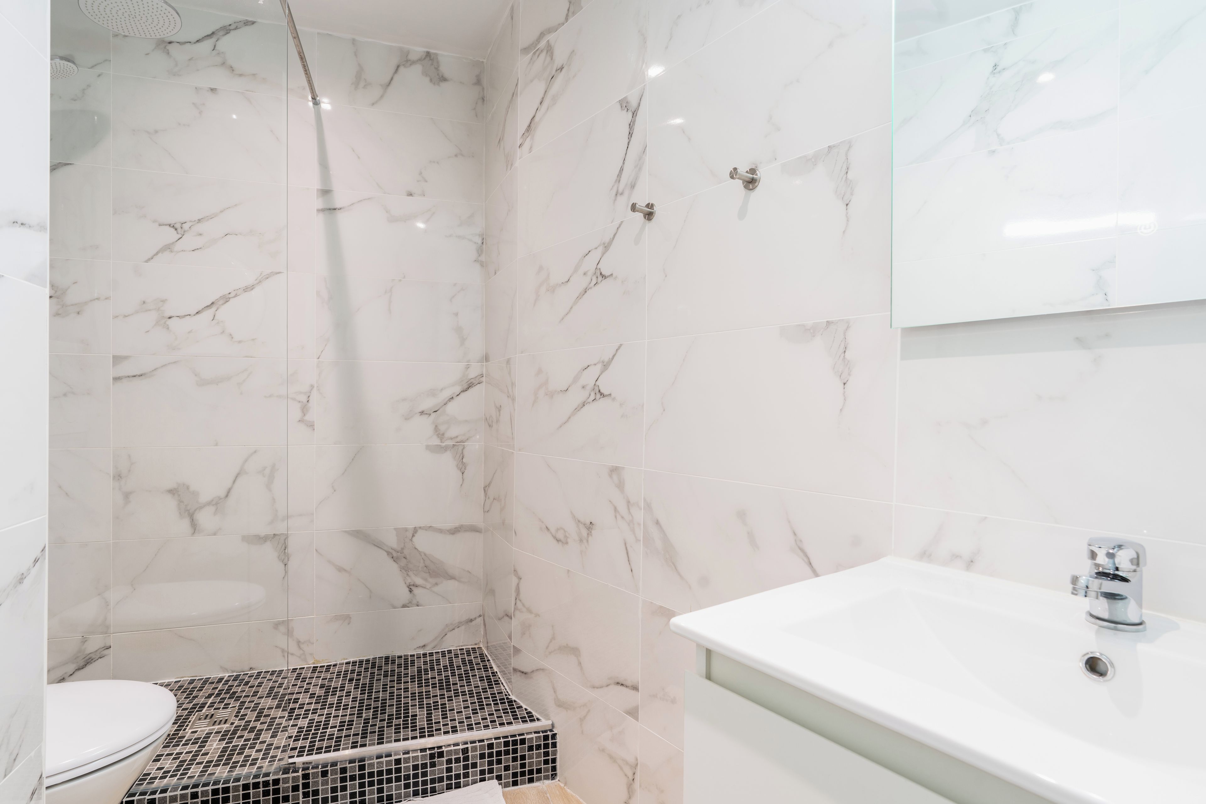 A bathroom with a shower, toilet, and sink.