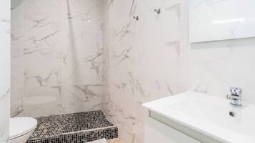 A bathroom with a shower, toilet, and sink.