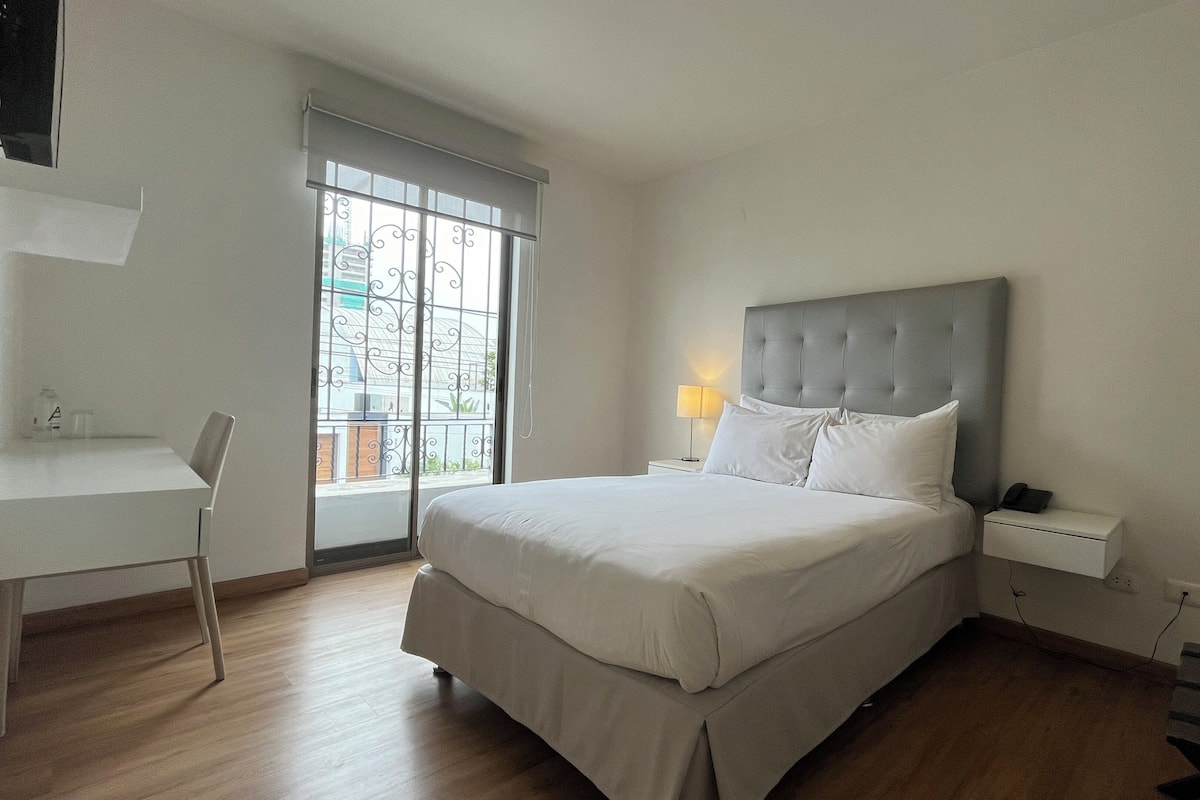 Un dormitorio con una cama, un escritorio y una silla.