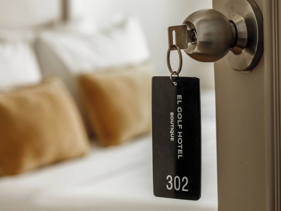 Porta de quarto de hotel com um cartão chave identificado como 'EL GOLF HOTEL BOUTIQUE 302'.