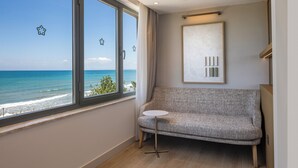 A room with a view of the ocean, a grey sofa, a small white table, and a framed artwork on the wall. - Side Star Beach Hotel - Ultra All Inclusive (Manavgat)