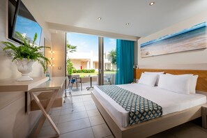 A modern hotel room with a large bed, a desk, a potted plant, and a view of the outdoors. - Royal & Imperial Belvedere Resort - All inclusive (Hersonissos)