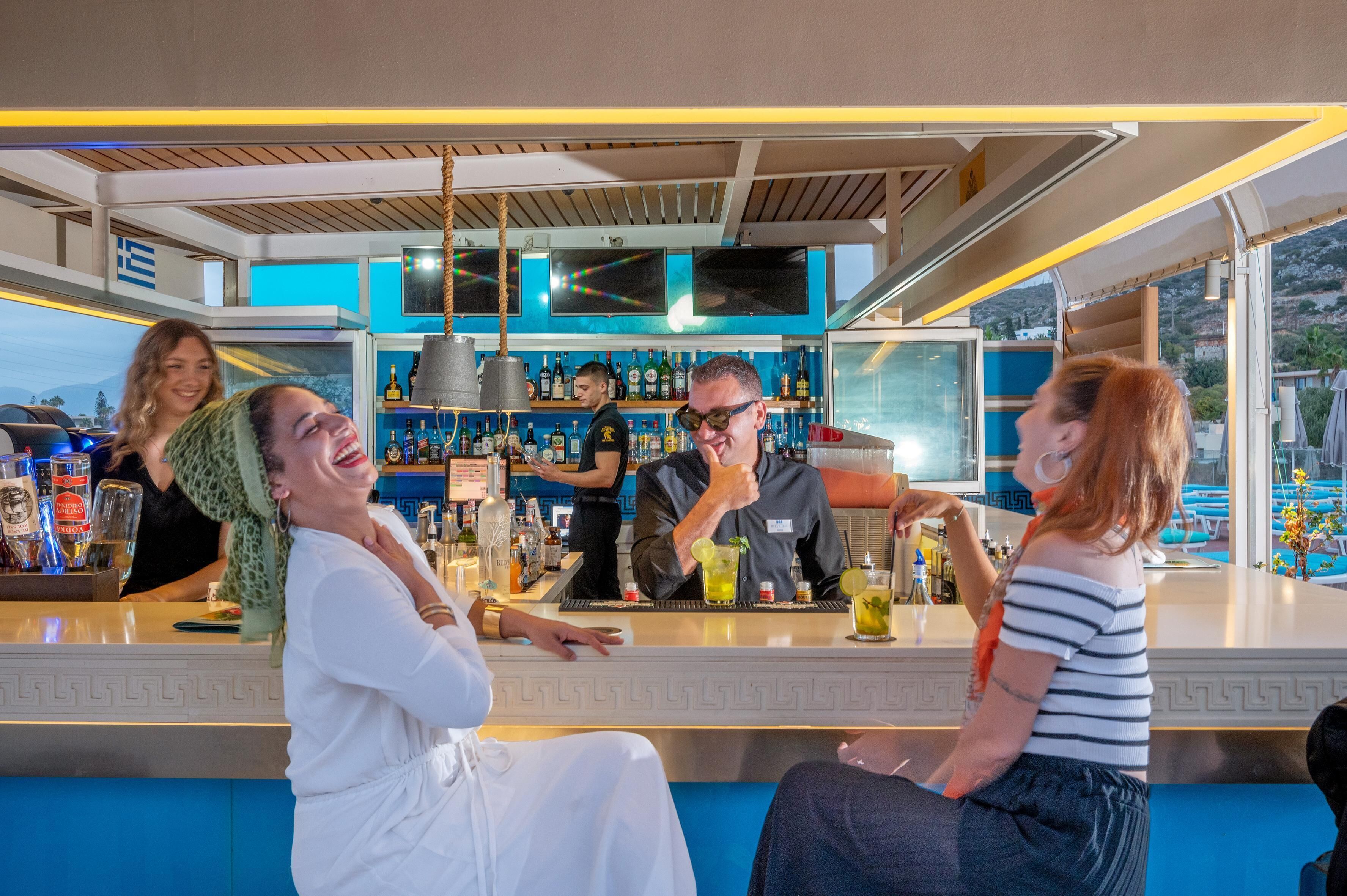 A bar area with a counter, bar stools, and a bartender.