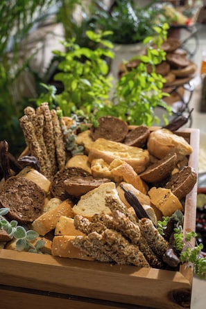 A wooden box filled with various types of bread and crackers.