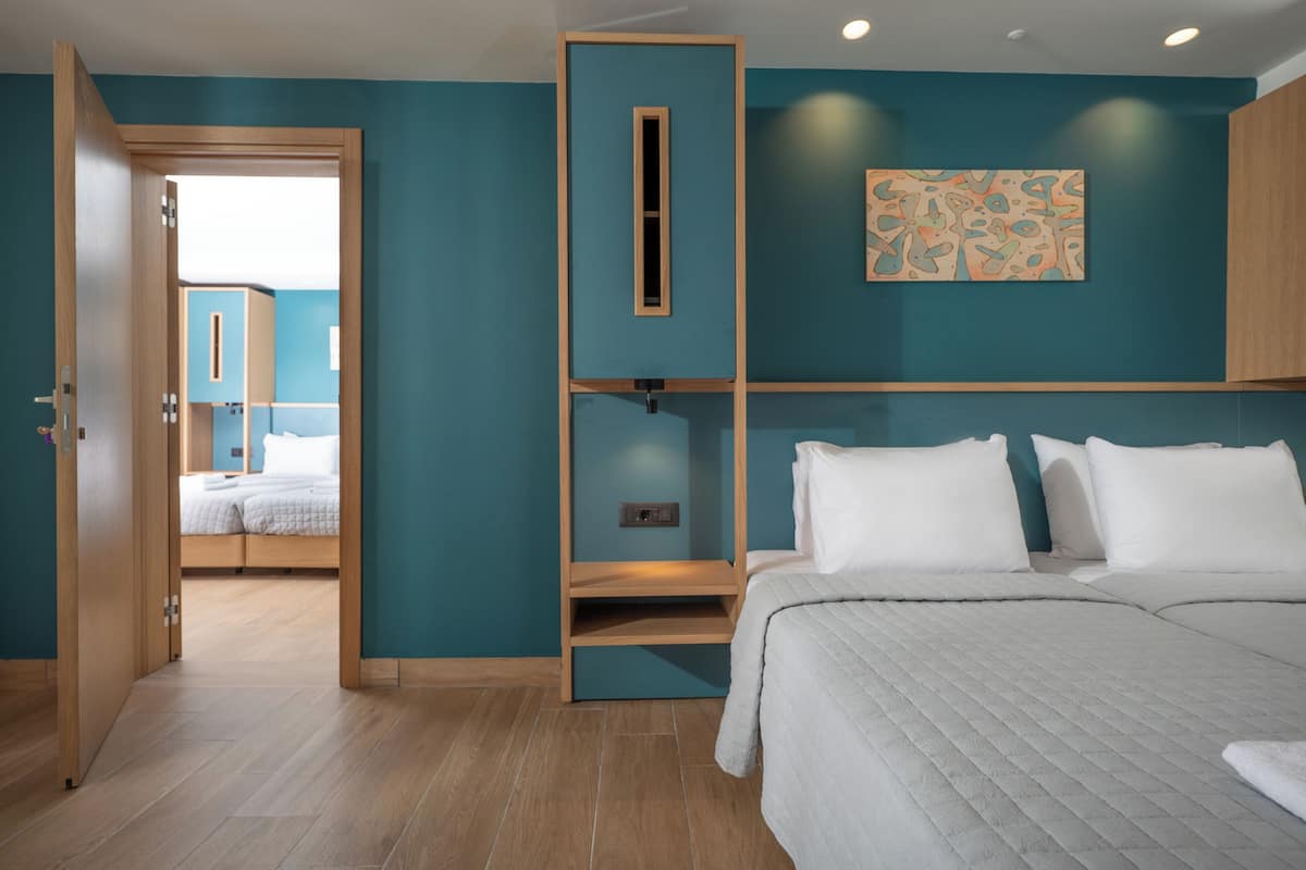 Un dormitorio con cama, un armario de madera, estante y puerta que da a otra habitación.