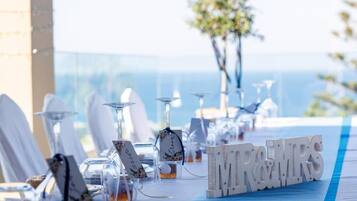 Une table de réception de mariage avec un chemin de table à rayures bleues, de la verrerie transparente et un panneau indiquant « M. et Mme ».