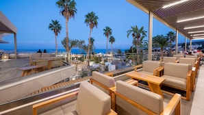 A rooftop terrace with outdoor seating, palm trees, and a view of the sea. - Royal & Imperial Belvedere Resort - All inclusive (Hersonissos)