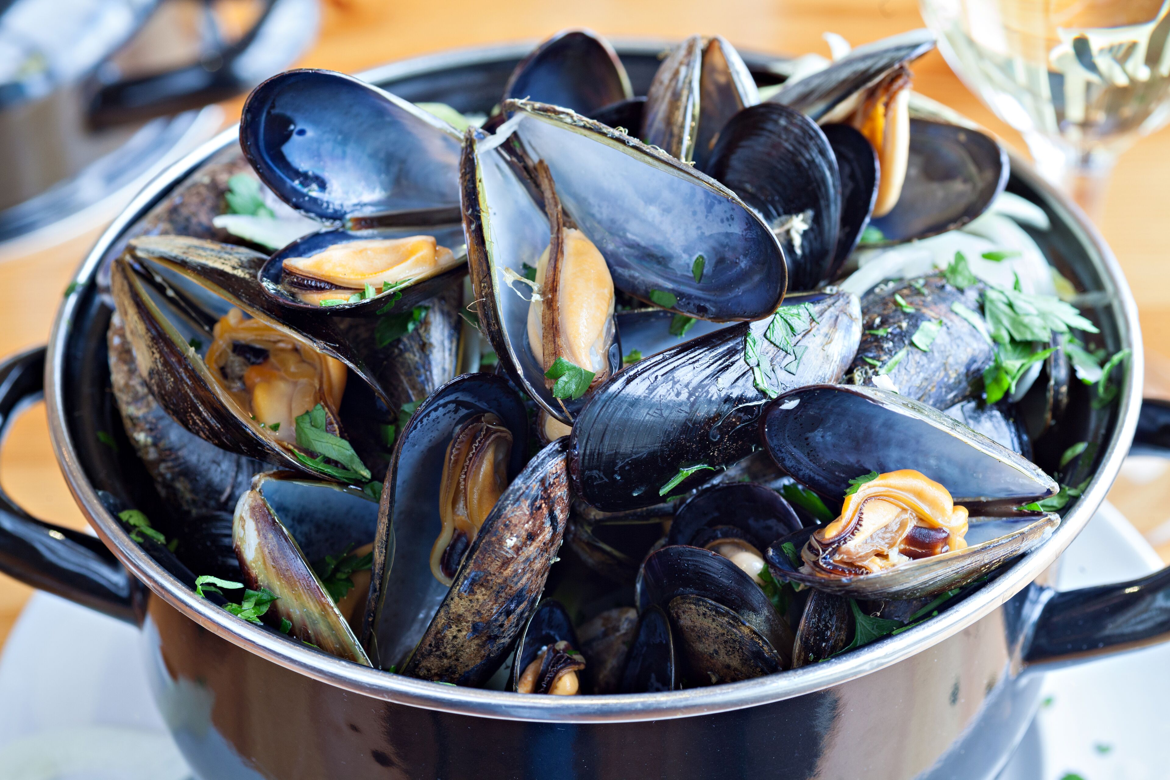 A pot of mussels with herbs.