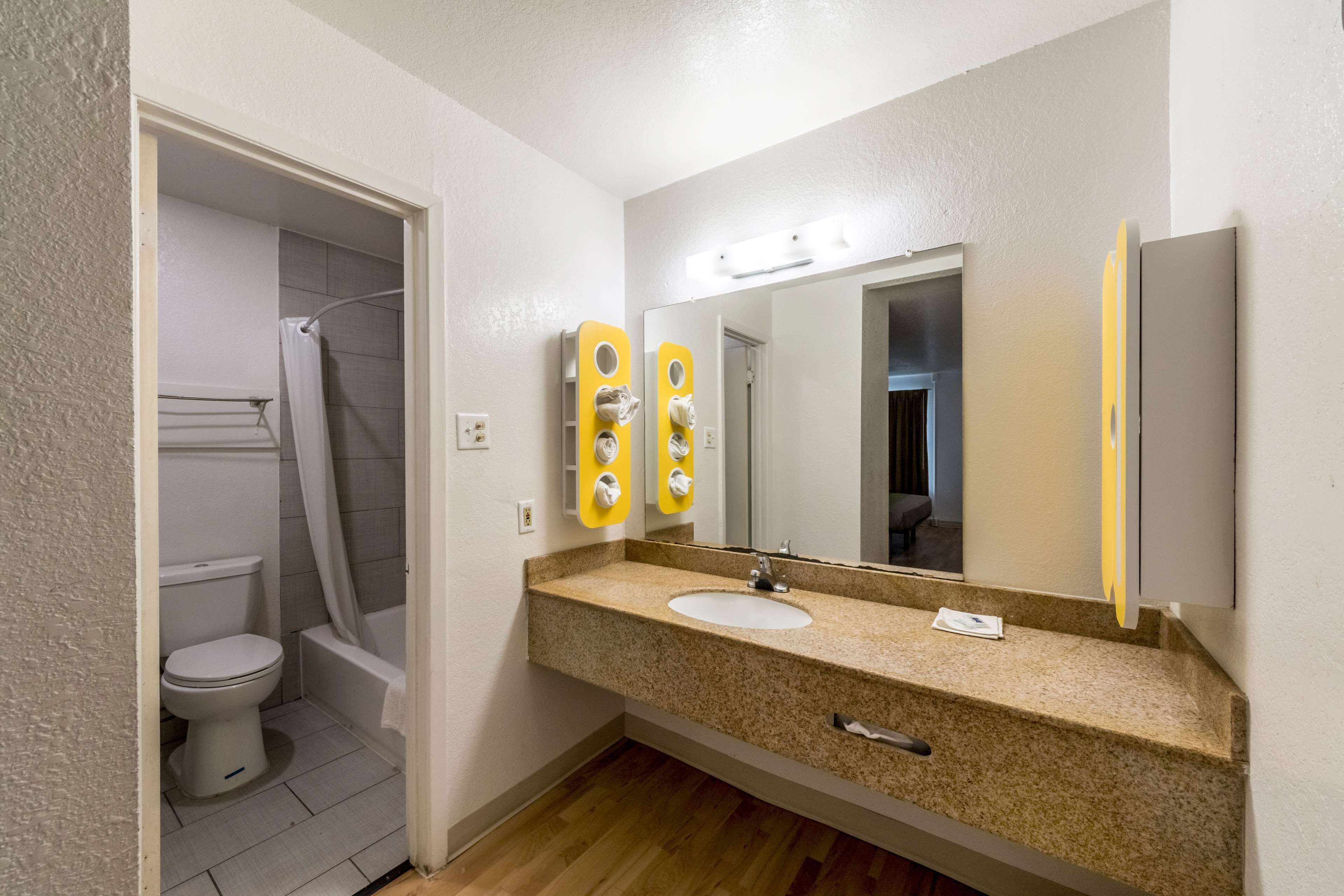 Ein Badezimmer mit Waschbecken, Spiegel und Toilette.
