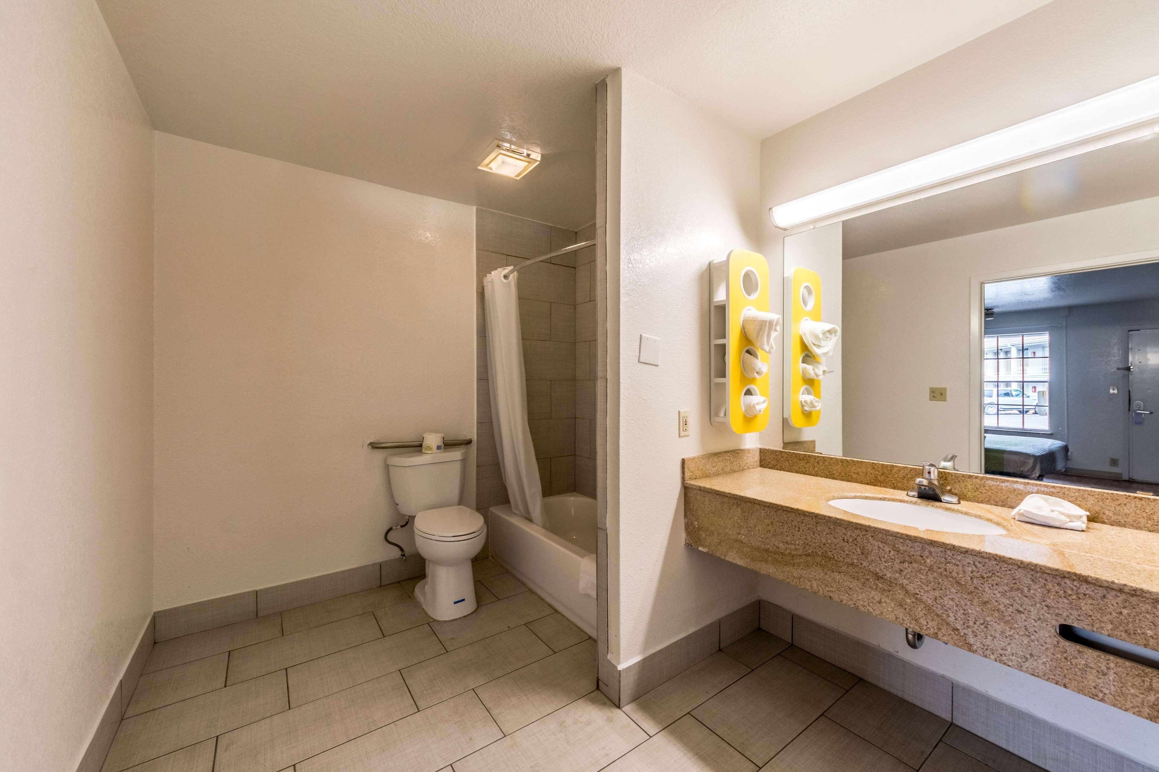 A modern bathroom with a shower, toilet, and sink.
