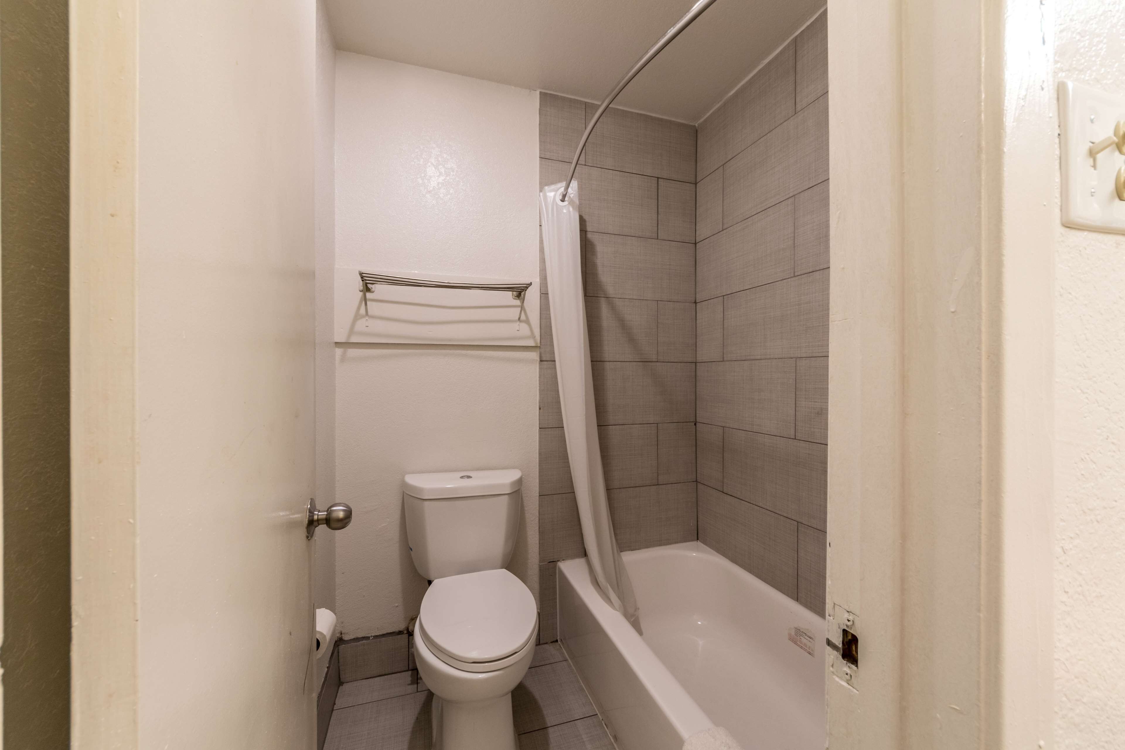 Un baño pequeño con inodoro, bañera y cortina de ducha.